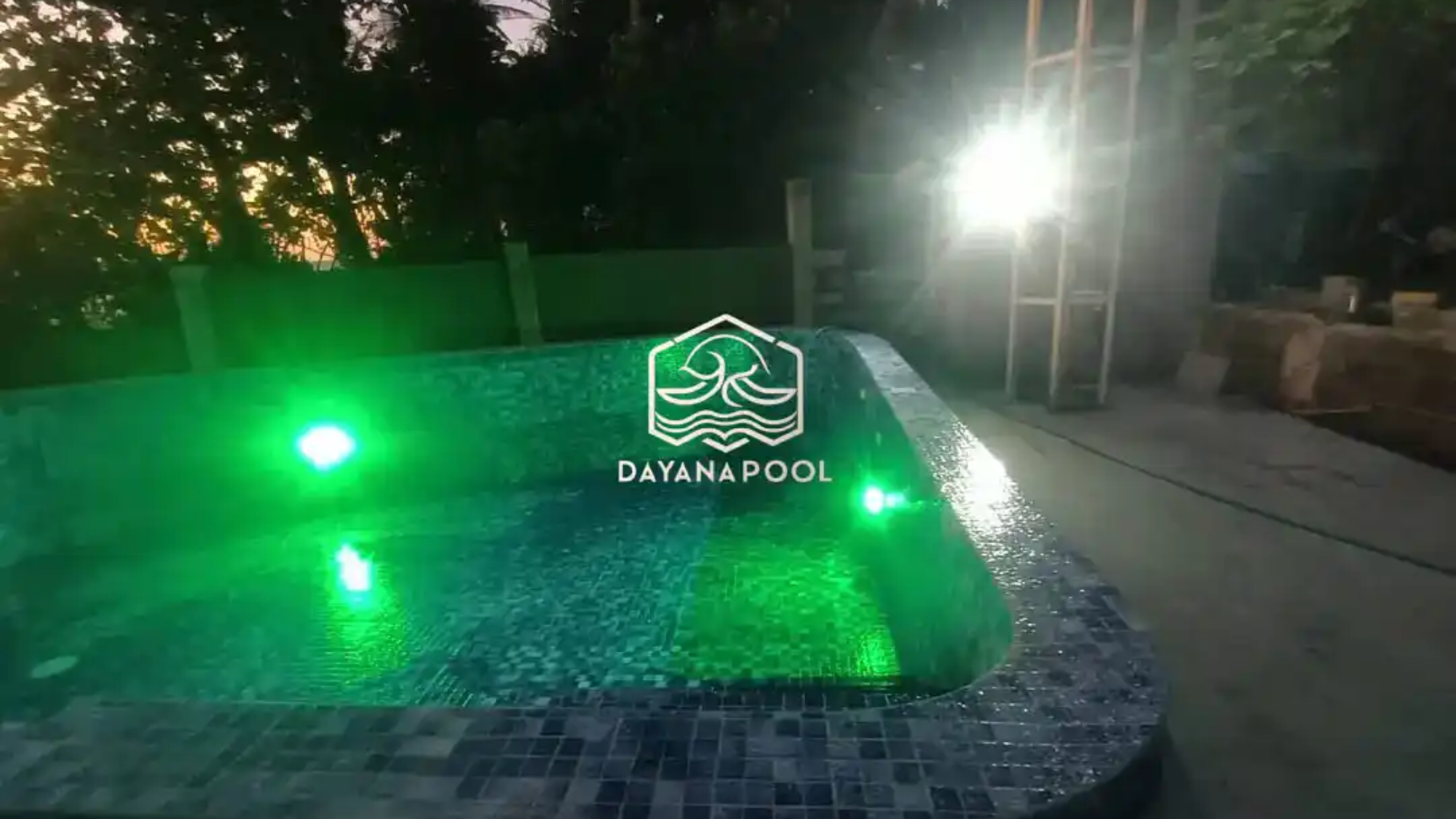 kolam renang dengan lampu kolam berwarna hijau di tepi pantai