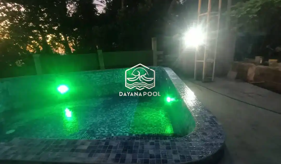 kolam renang dengan lampu kolam berwarna hijau di tepi pantai