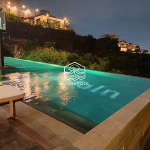 kolam renang infinity dengan cahaya lampu di malam hari