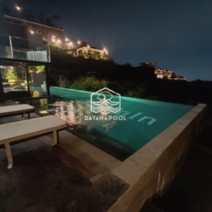 kolam renang infinity dengan cahaya lampu di malam hari