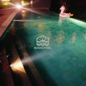 kolam renang infinity dengan cahaya lampu di malam hari