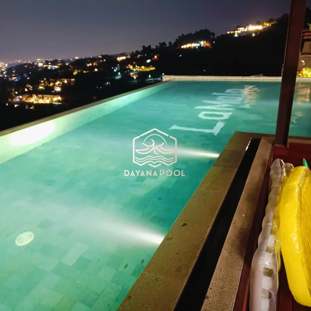 kolam renang infinity dengan cahaya lampu di malam hari