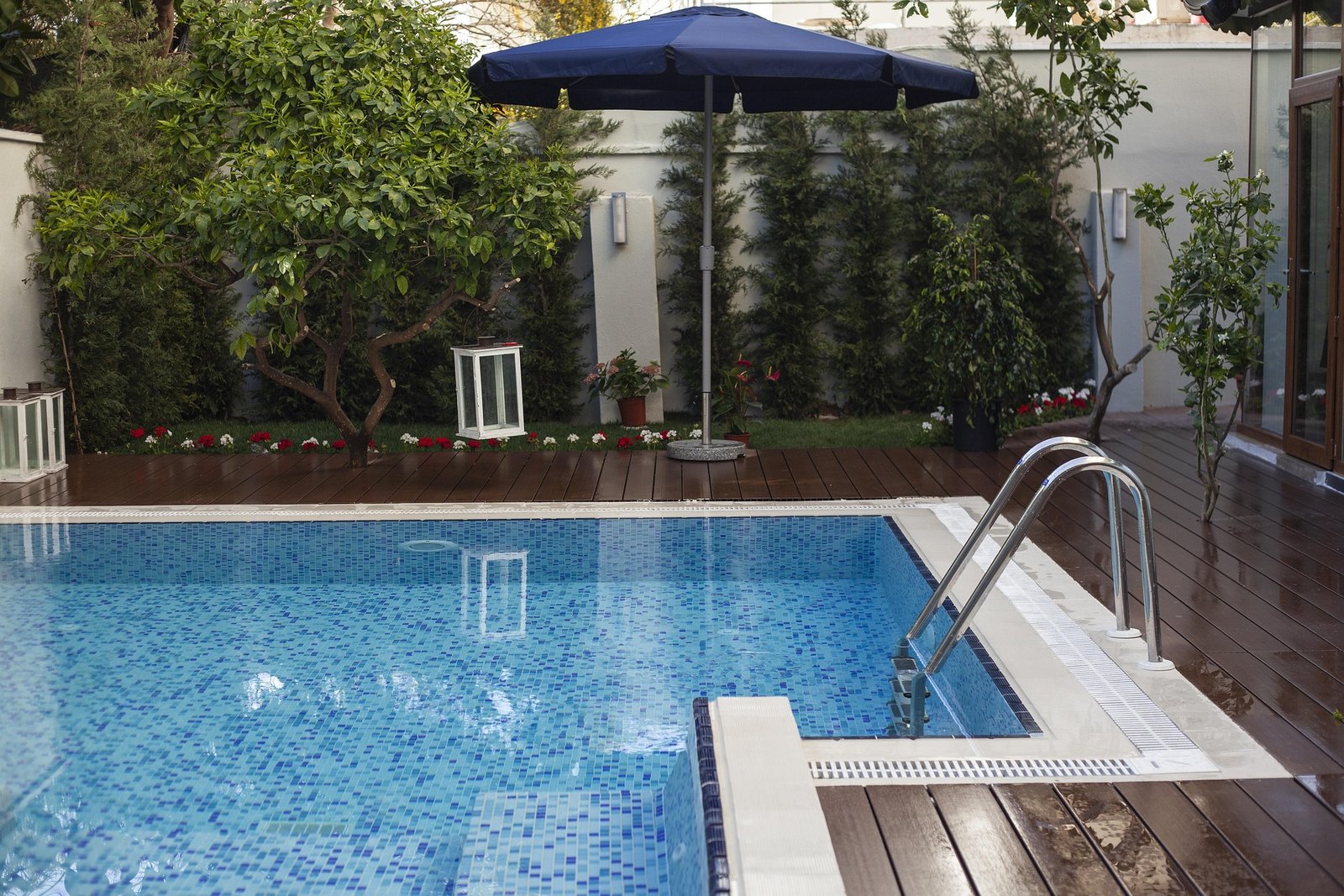 Kolam renang minimalis dengan mozaik kudalaut dan deck conwood