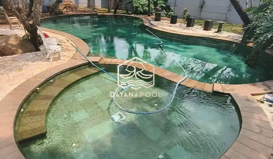 kolam renang oval yang indah dengan finidhing batu alam