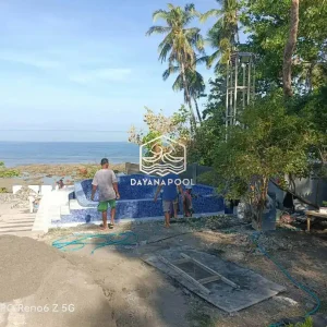 kolalm renang semi overflow dengan keramik biru di tepi pantai buatan dayanapool