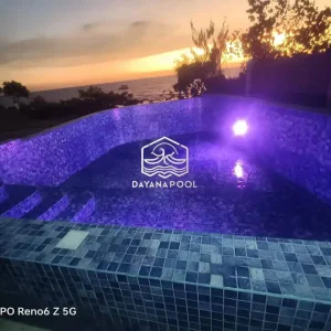 kolam renang dengan lampu kolam berwarna Ungu di tepi pantai